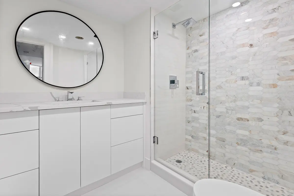 A luxury bathroom with oval shaped mirror